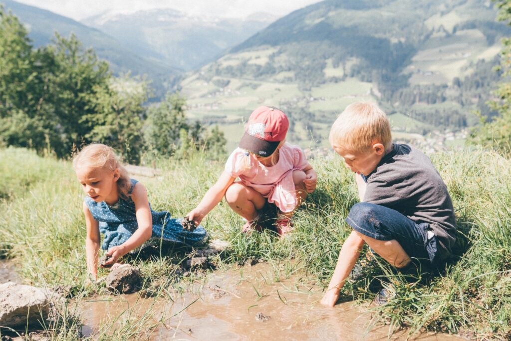 Kinder spielen auf einer Alm